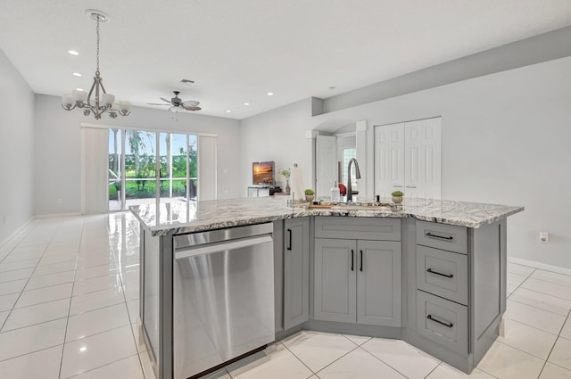 kitchen with dishwasher, a center island with sink, ceiling fan with notable chandelier, hanging light fixtures, and gray cabinets