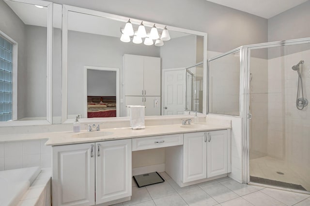 bathroom featuring shower with separate bathtub, vanity, and tile patterned floors