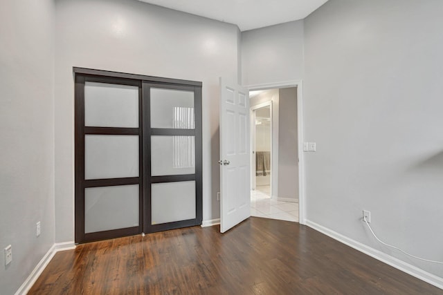 foyer entrance featuring a towering ceiling and wood-type flooring