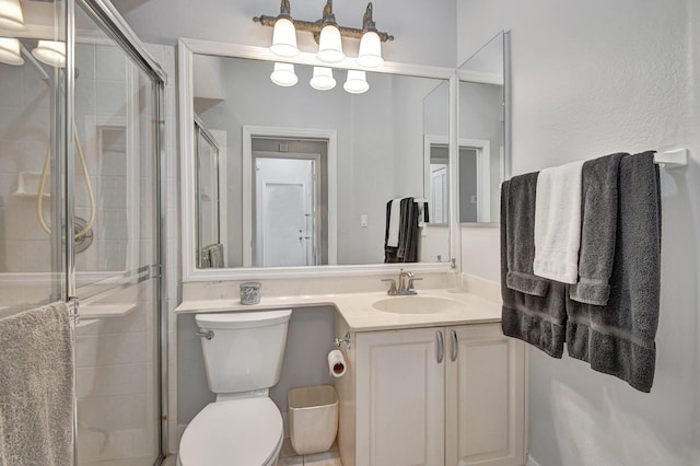 bathroom featuring vanity, toilet, and a shower with door