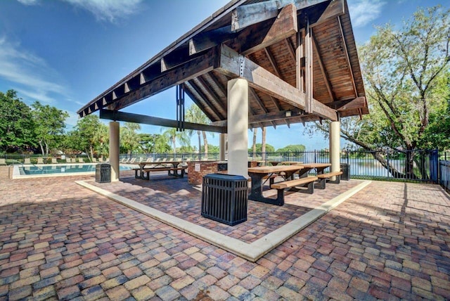 view of property's community with a gazebo, a water view, and a swimming pool