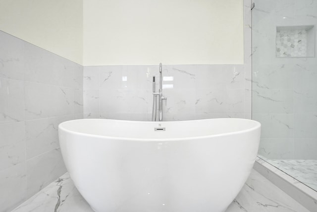 bathroom featuring tile walls and a tub