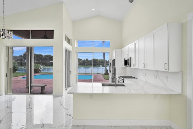 kitchen with sink, kitchen peninsula, decorative light fixtures, white cabinetry, and stainless steel appliances