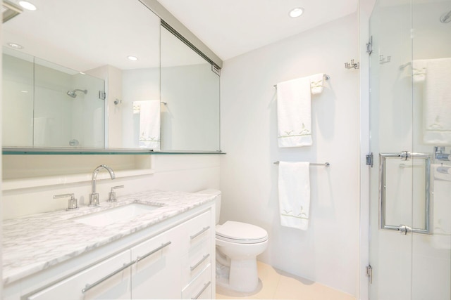 bathroom with tile patterned flooring, an enclosed shower, vanity, and toilet