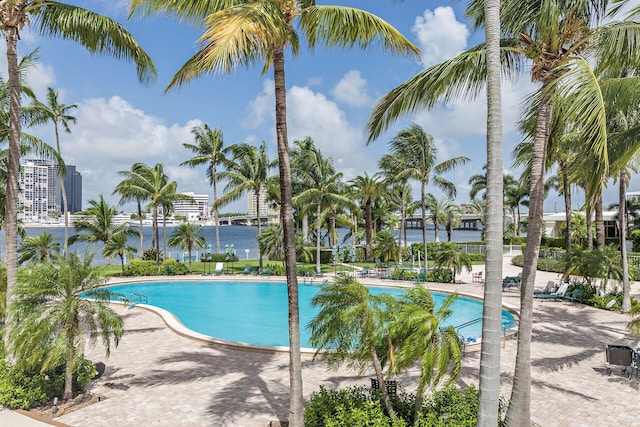 view of pool featuring a water view and a patio area