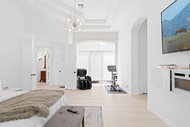 bedroom with light wood-type flooring and an inviting chandelier