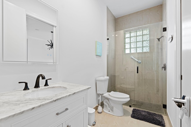 bathroom featuring tile patterned floors, vanity, toilet, and a shower with shower door