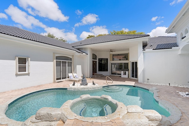 back of property with a pool with hot tub, ceiling fan, and a patio