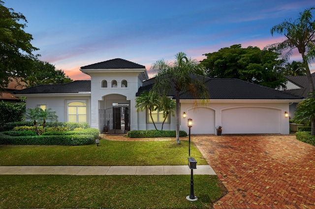 mediterranean / spanish-style house with a yard and a garage