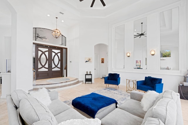 living room featuring light tile patterned floors, a towering ceiling, and an inviting chandelier