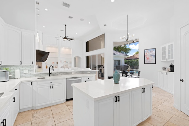 kitchen featuring white cabinets, dishwasher, a center island, and ceiling fan with notable chandelier