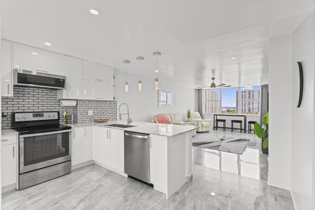 kitchen featuring kitchen peninsula, white cabinetry, sink, and stainless steel appliances