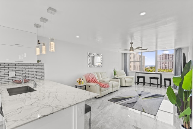 living room featuring ceiling fan and sink