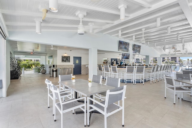 tiled dining area with wood ceiling, a healthy amount of sunlight, and beam ceiling