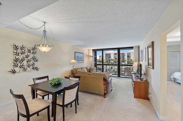 carpeted dining room featuring floor to ceiling windows and a textured ceiling