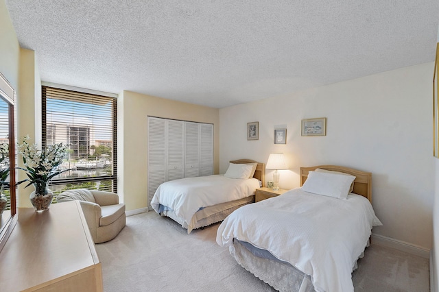 carpeted bedroom with a textured ceiling and a closet