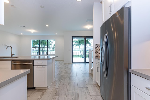 kitchen featuring appliances with stainless steel finishes, white cabinetry, and sink