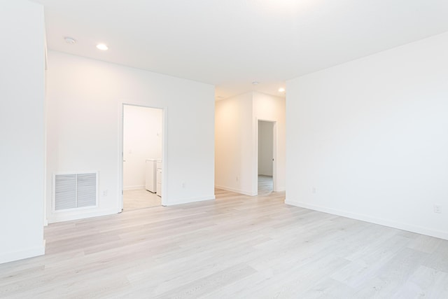 unfurnished room with independent washer and dryer and light wood-type flooring