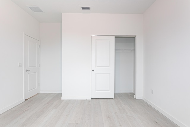 unfurnished bedroom featuring a closet and light hardwood / wood-style floors