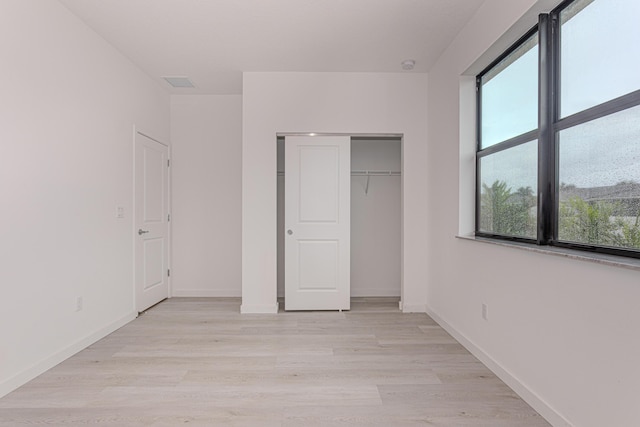 unfurnished bedroom featuring a closet and light wood-type flooring