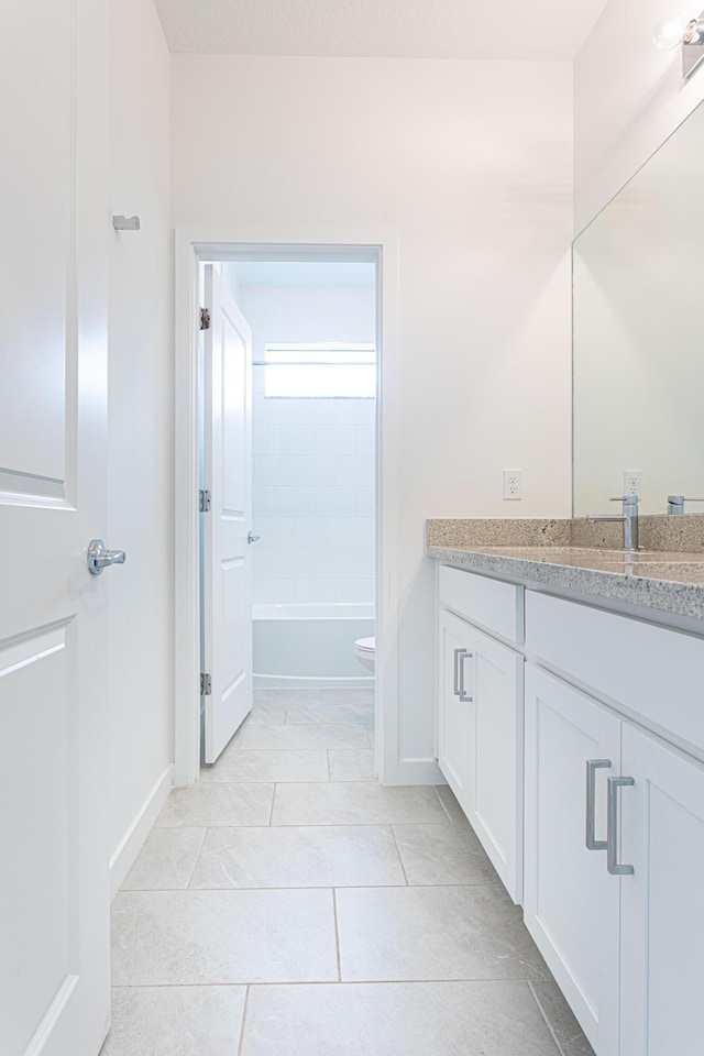 bathroom featuring tile patterned flooring, vanity, and toilet