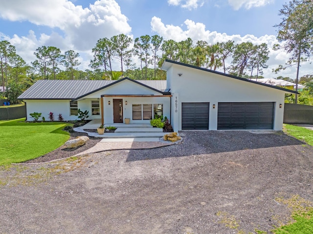 view of front facade featuring a garage, a front lawn, and a porch