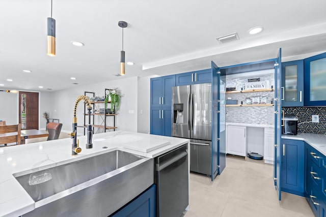 kitchen featuring stainless steel appliances, hanging light fixtures, tasteful backsplash, and blue cabinets