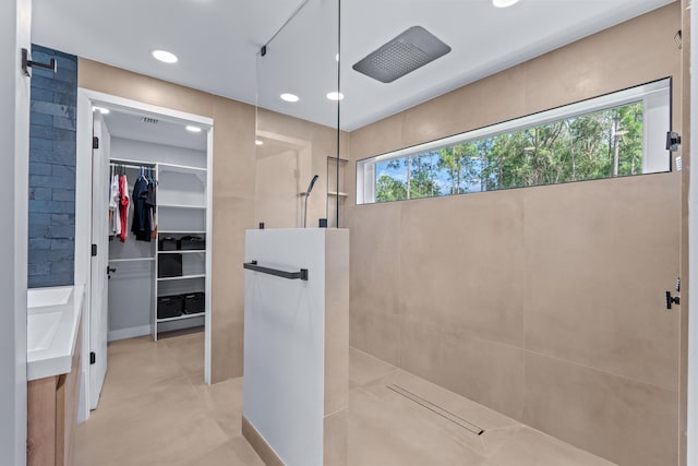 bathroom with walk in shower, vanity, concrete floors, and plenty of natural light