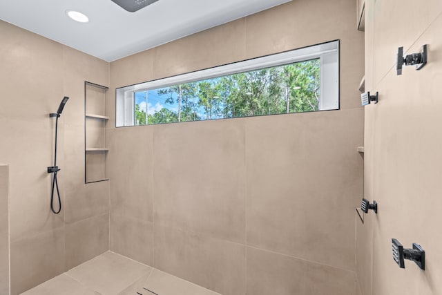 bathroom featuring tile patterned flooring and tiled shower