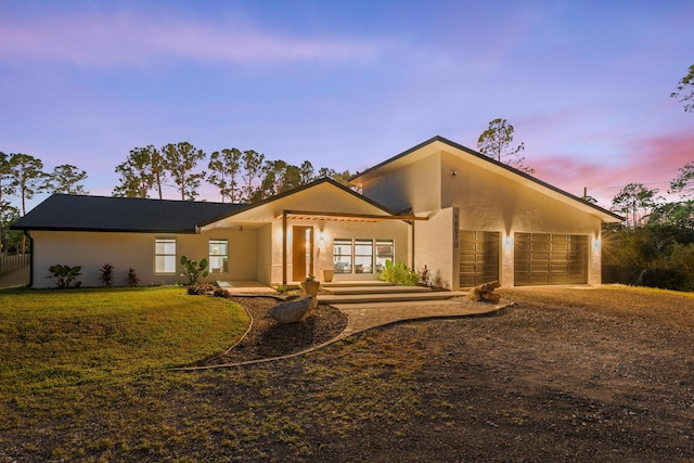 view of front of property with a garage and a yard