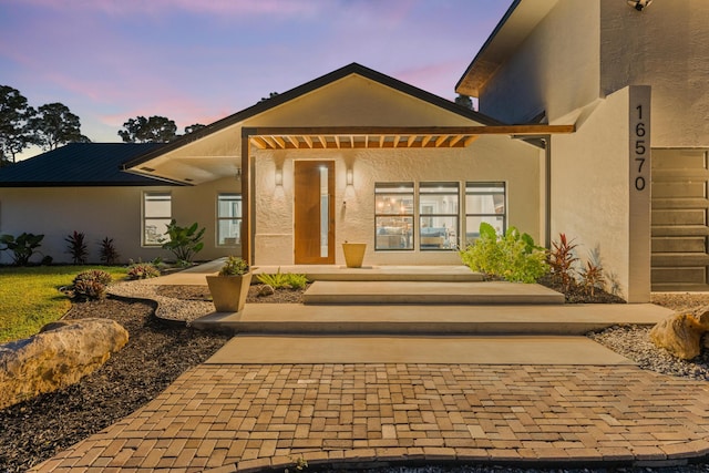 view of exterior entry at dusk