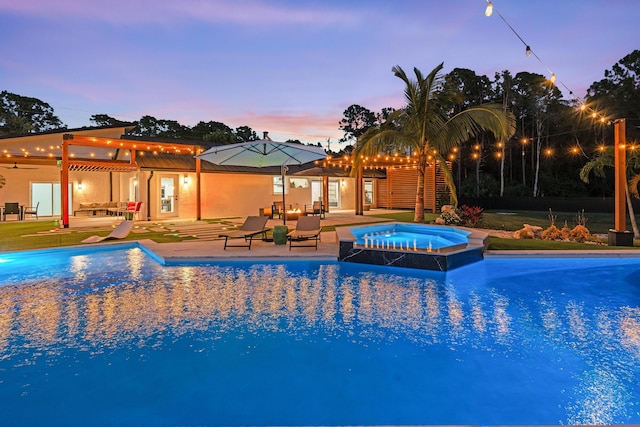 pool at dusk with a patio, a pergola, and an in ground hot tub