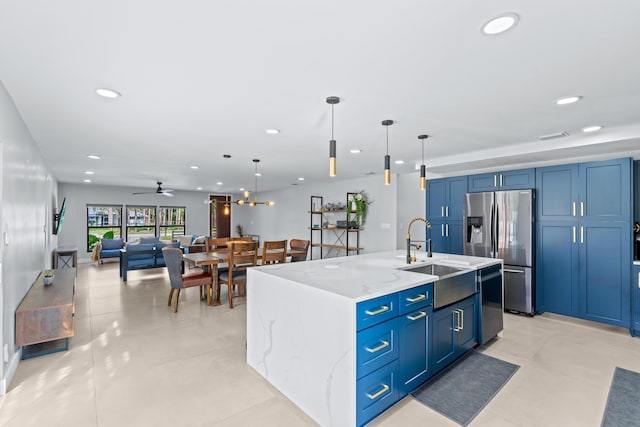 kitchen featuring stainless steel appliances, a large island, pendant lighting, light stone countertops, and sink