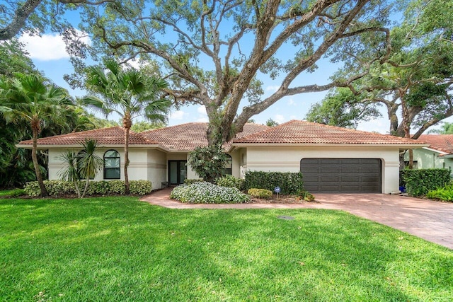 mediterranean / spanish-style house featuring a front lawn and a garage