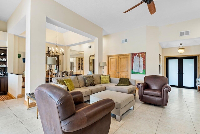 living room featuring light tile patterned floors, ceiling fan with notable chandelier, and french doors