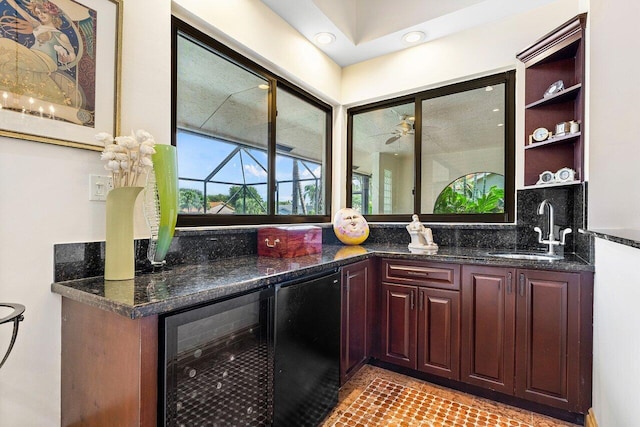 bar with tasteful backsplash, black fridge, beverage cooler, sink, and dark stone countertops