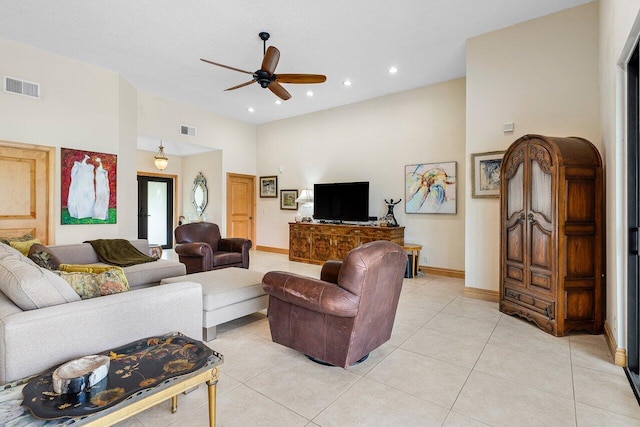 tiled living room with ceiling fan and a towering ceiling