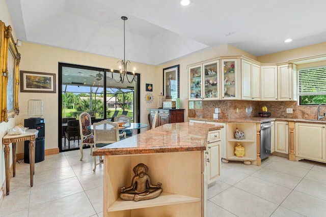 kitchen featuring light stone counters, sink, a chandelier, a center island, and hanging light fixtures