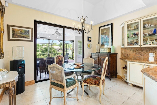 tiled dining room featuring ceiling fan with notable chandelier