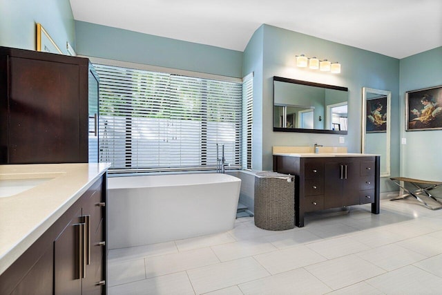 bathroom with tile patterned flooring, vanity, and a tub