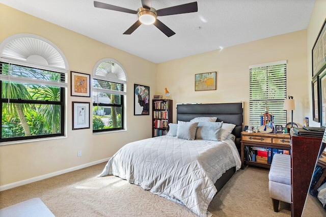 carpeted bedroom featuring a textured ceiling and ceiling fan