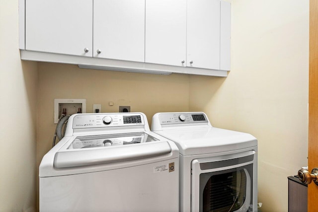 washroom with cabinets and washing machine and dryer