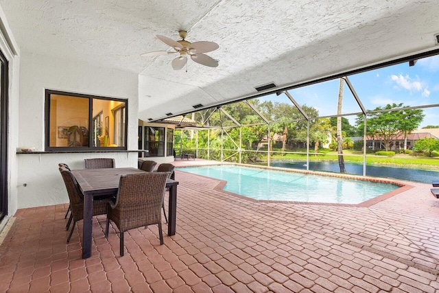 view of swimming pool with a water view, a patio area, ceiling fan, and a lanai