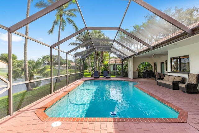 view of swimming pool featuring outdoor lounge area, ceiling fan, a patio area, and glass enclosure