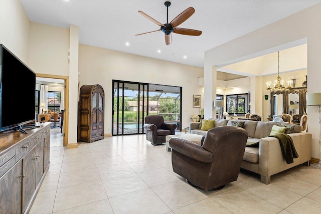 tiled living room with ceiling fan with notable chandelier and a towering ceiling