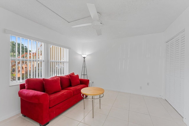 living room with a textured ceiling, tile patterned floors, and ceiling fan