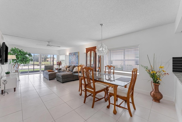 dining space with a textured ceiling, light tile patterned floors, and ceiling fan with notable chandelier