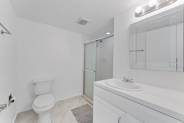 bathroom with an enclosed shower, vanity, and toilet