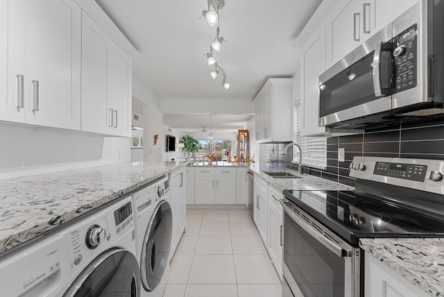 kitchen featuring separate washer and dryer, white cabinetry, sink, appliances with stainless steel finishes, and light tile patterned floors