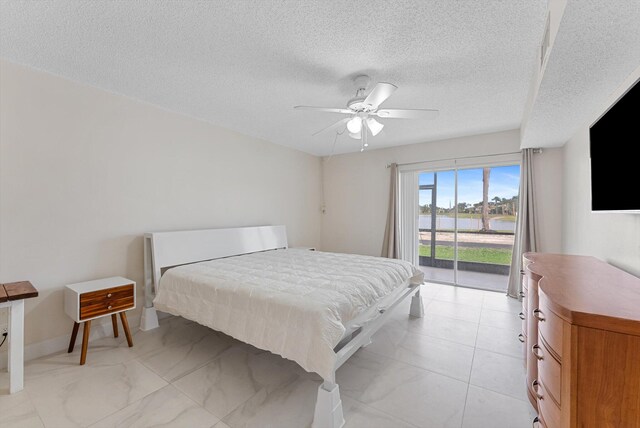 bedroom featuring access to outside, a textured ceiling, and ceiling fan